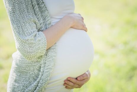 Schwangere Frau hält den Bauch mit ihren Händen